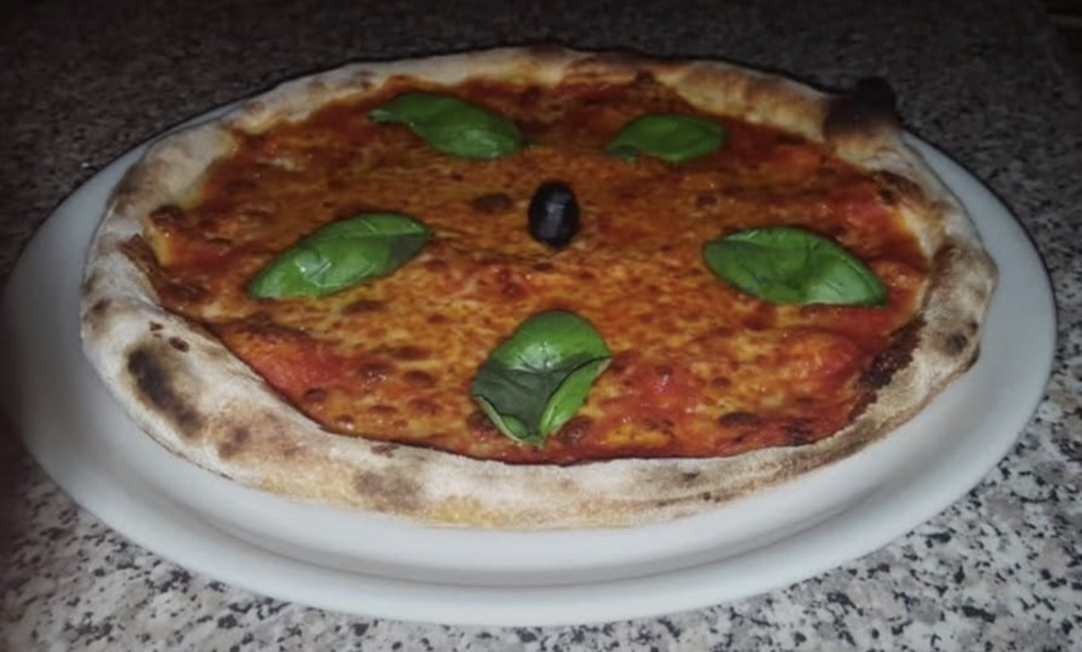 Pizza mit Tomaten, Käse und Basilikum